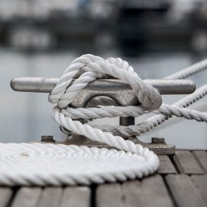 Mooring rope on mooring cleat. Coiled mooring line.